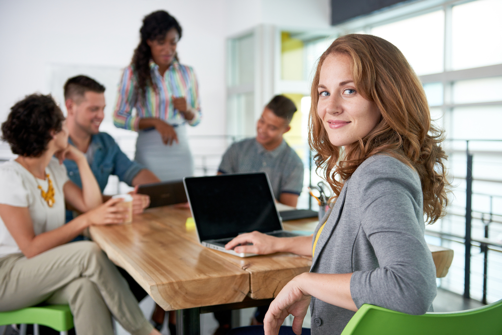 Image of a succesful casual business woman using laptop during meeting Image of a succesful casual business woman using laptop during meeting